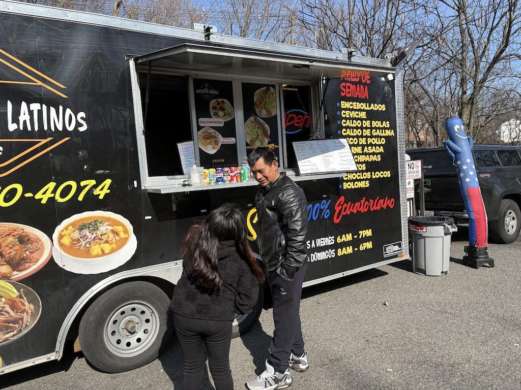 Customers wait for their orders at an Ecuadorian food truck in Spring Valley, N.Y., a suburb of New York City. The area was one of the largest magnets for asylum-seekers from the border, mostly from Ecuador.