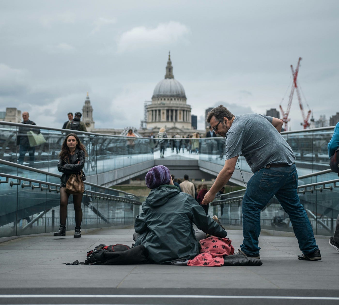 A man helping another person out with money on the street. A man helping another person out with money on the street.