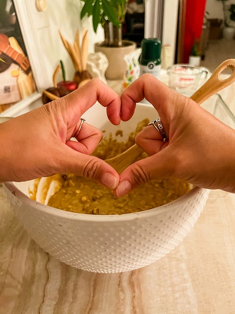 Photo of two women with a mountain landscape in the background; selfie photo of two women and a dog in a car; Selfie photo of woman with a dog sitting in a car; selfie photo of a family of four adults: brother and sister, and mom and dad; photo of two hands in shape of a heart in foreground and a mixing bowl with banana bread mix behind and below it; a baked banana bread in a glass loaf pan atop a stove; a photo of a carrot cake with glazed frosting and chopped pecans sprinkled on top; photo of a garden plot of blossoming flowers and vegetables and a placard in front that reads 'community garden'; photo of dog on couch curled up next to photographer's legs.