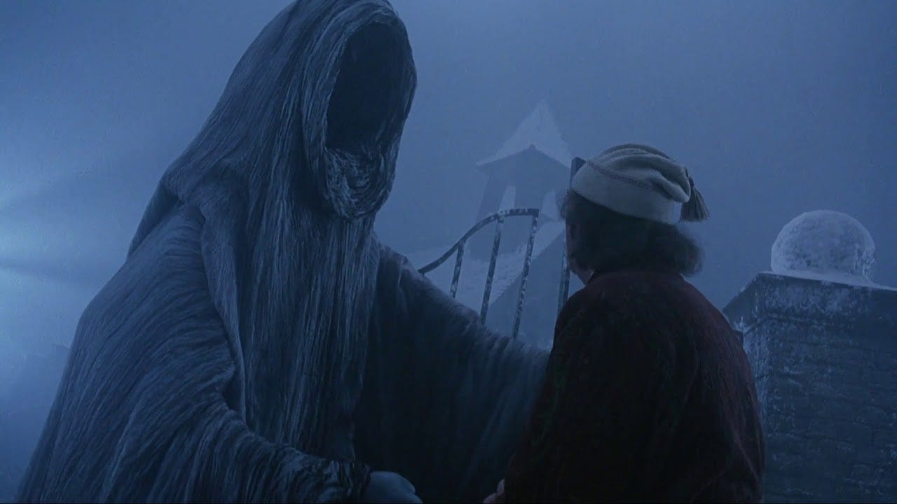 A tall faceless figure in a gray cloak extends its arms toward a shorter person with gray hair wearing a stocking cap. They are standing in a snowy cemetery. A tall faceless figure in a gray cloak extends its arms toward a shorter person with gray hair wearing a stocking cap. They are standing in a snowy cemetery.