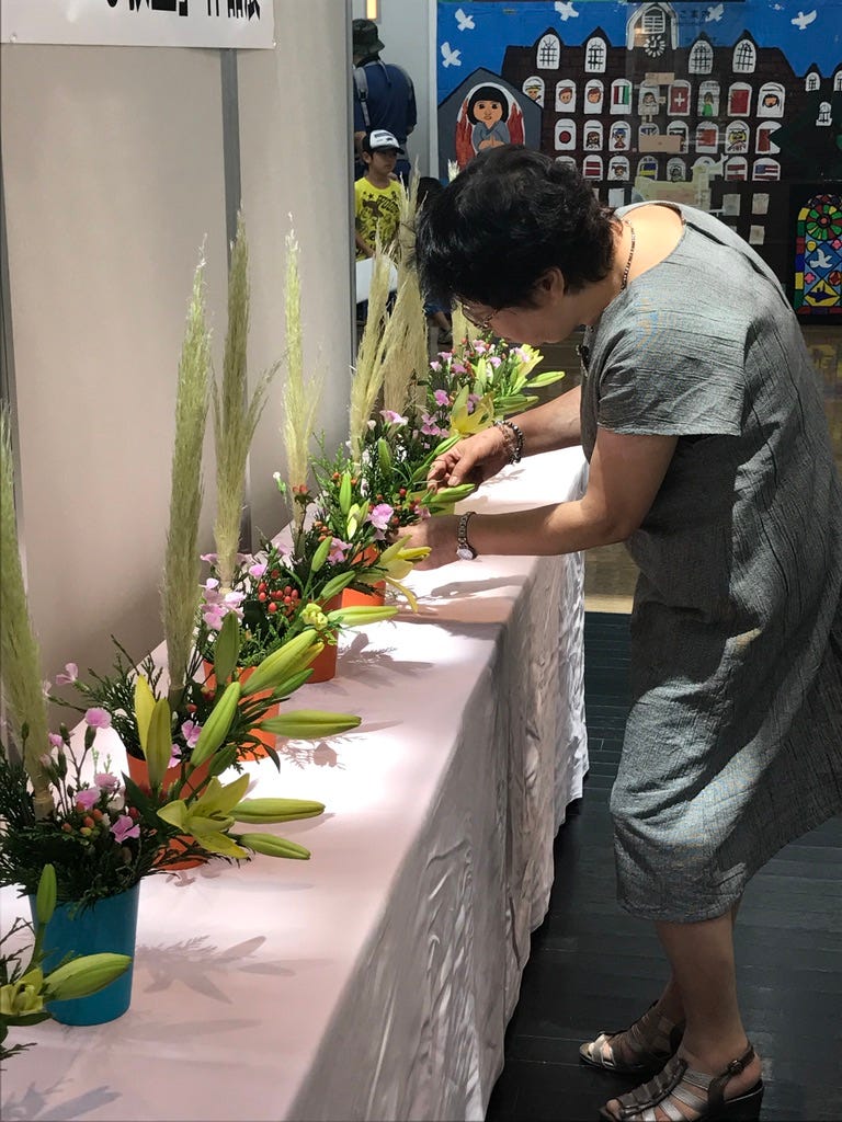 ikebana students put final touches on arrangement