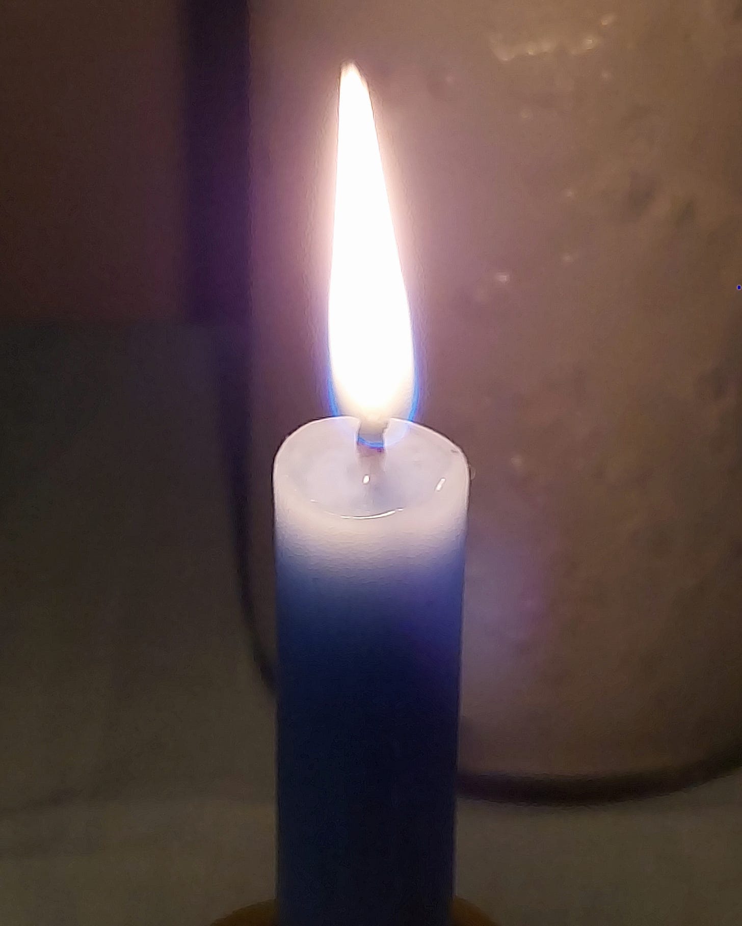 A close up of a blue chime candle burning brightly.