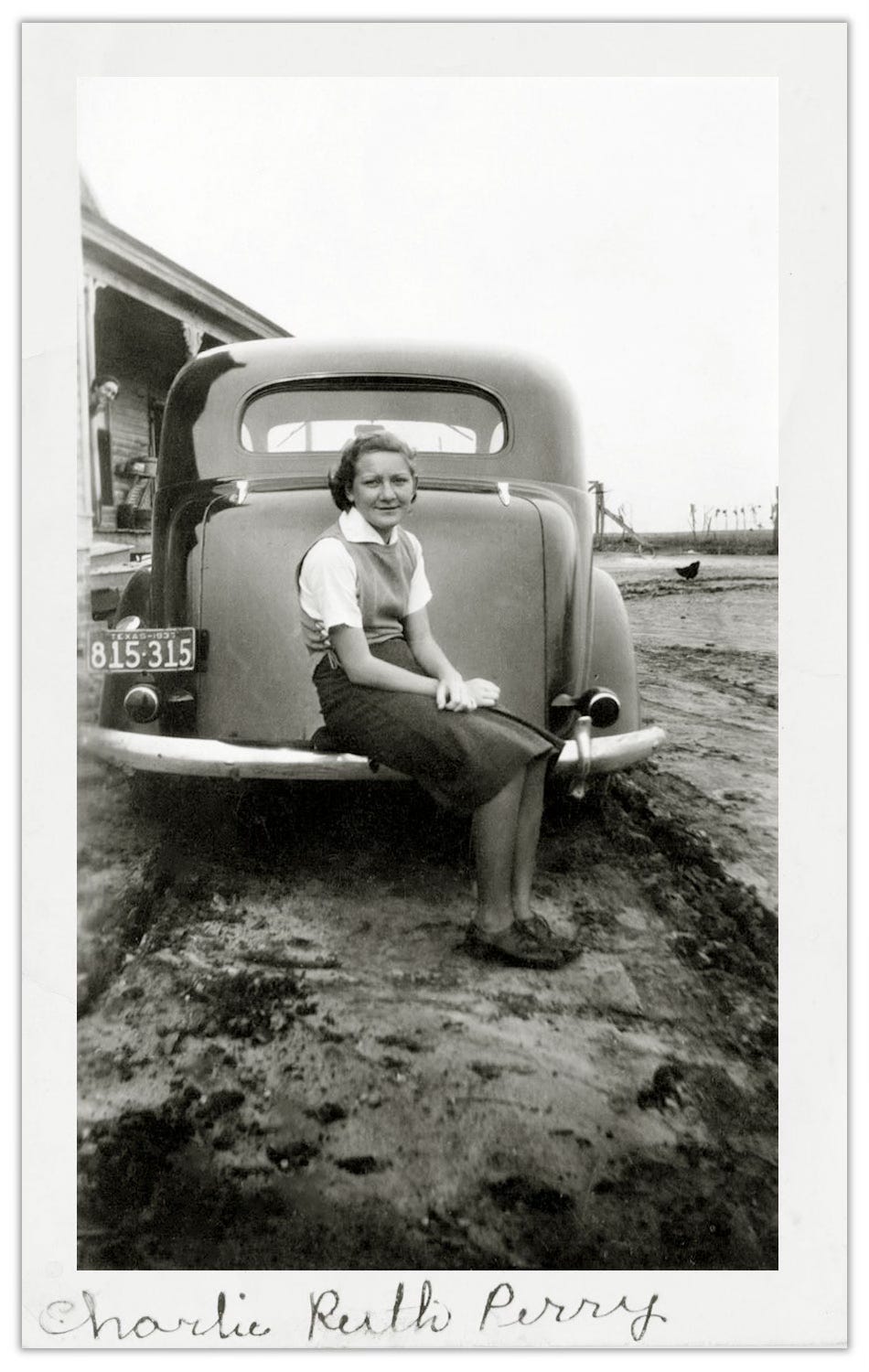 Old photo of women sitting on bumper of car