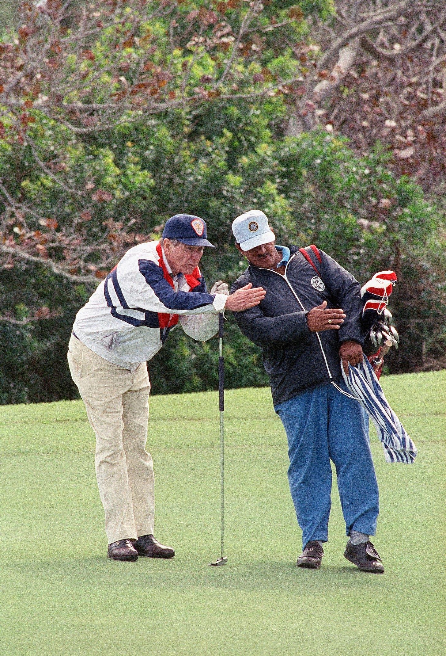 President George H.W. Bush receives putting advice from caddy John Kelly at the Mid Ocean Club in Bermuda, March 17, 1991, combining summit meetings with recreation. President George H.W. Bush receives putting advice from caddy John Kelly at the Mid Ocean Club in Bermuda, March 17, 1991, combining summit meetings with recreation.