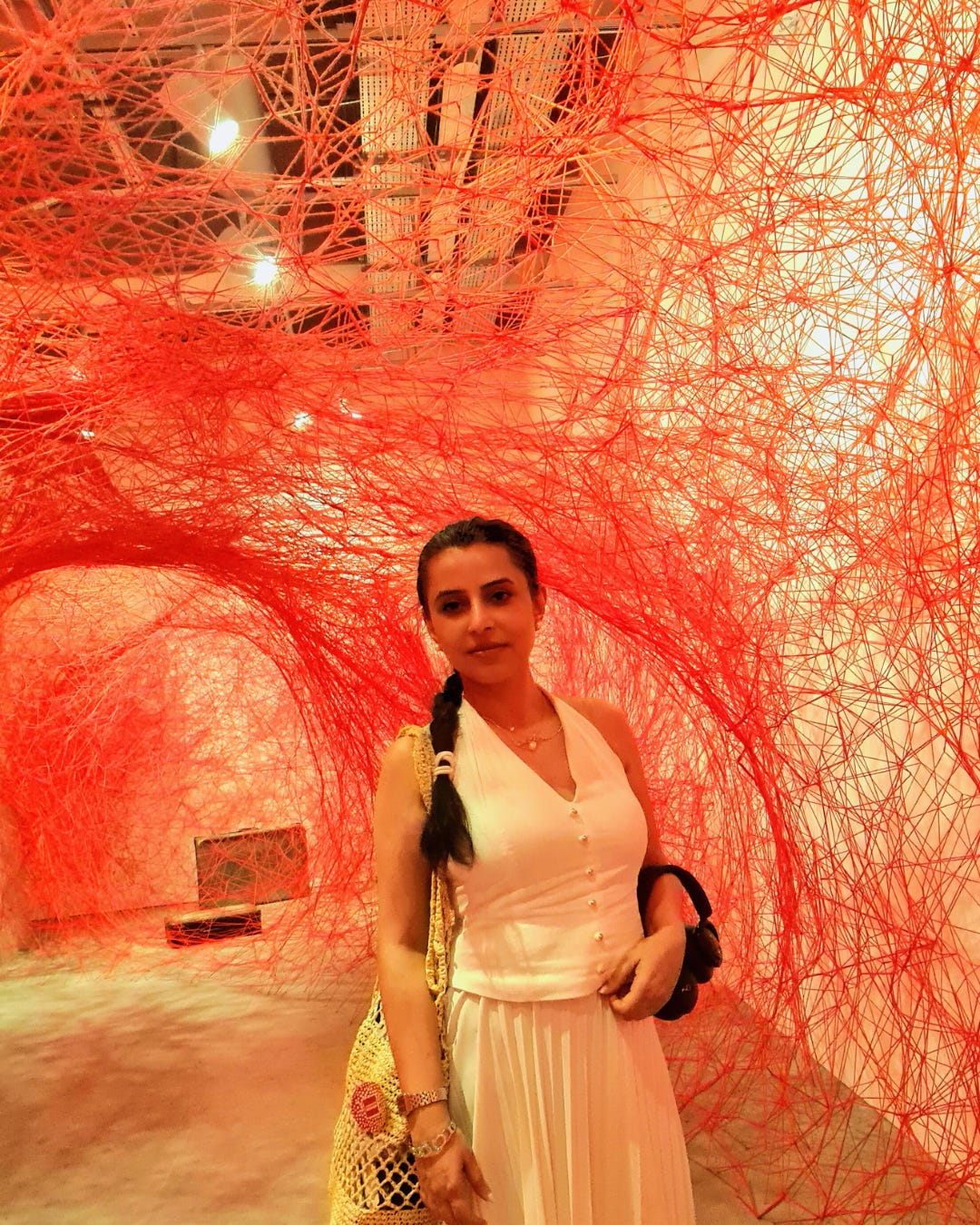 shiota japanese artist installation at Istanbul museum of modern art. A visitor standing in red shioto installation wearing white dress. shiota japanese artist installation at Istanbul museum of modern art. A visitor standing in red shioto installation wearing white dress.