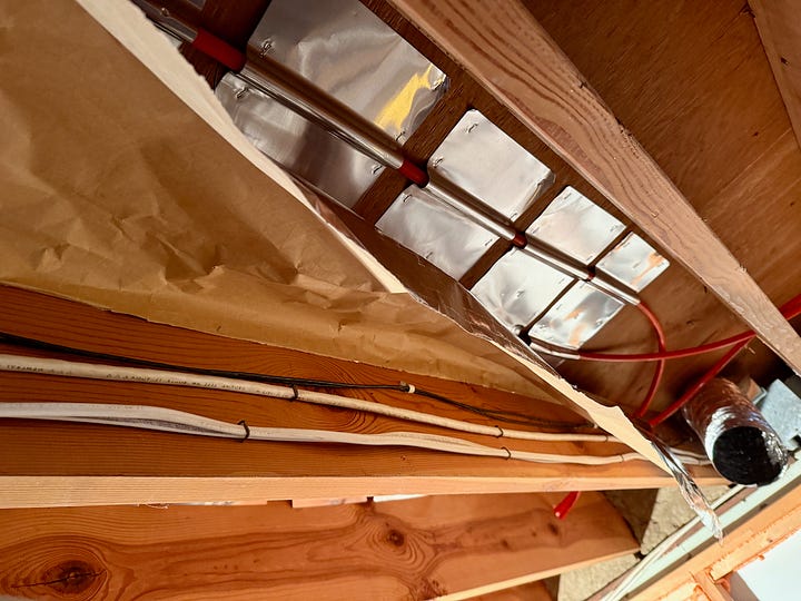 Two images showing the PEX tubing being installed under a floor.