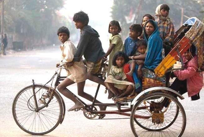 Ten people on a cycle rickshaw in India