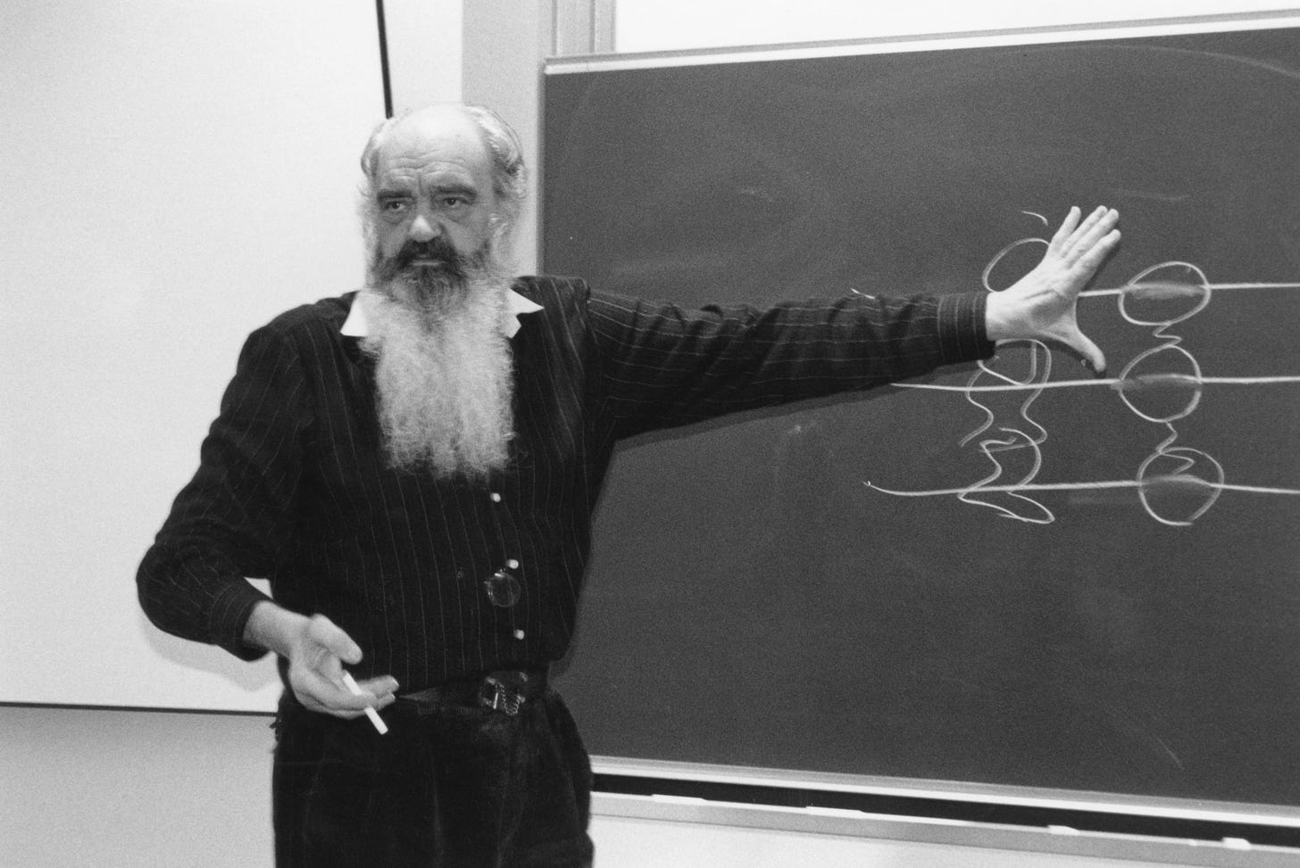 Stafford Beer presenting a systems diagram, illustrating the cybernetic foundations of organizational governance. Stafford Beer presenting a systems diagram, illustrating the cybernetic foundations of organizational governance.