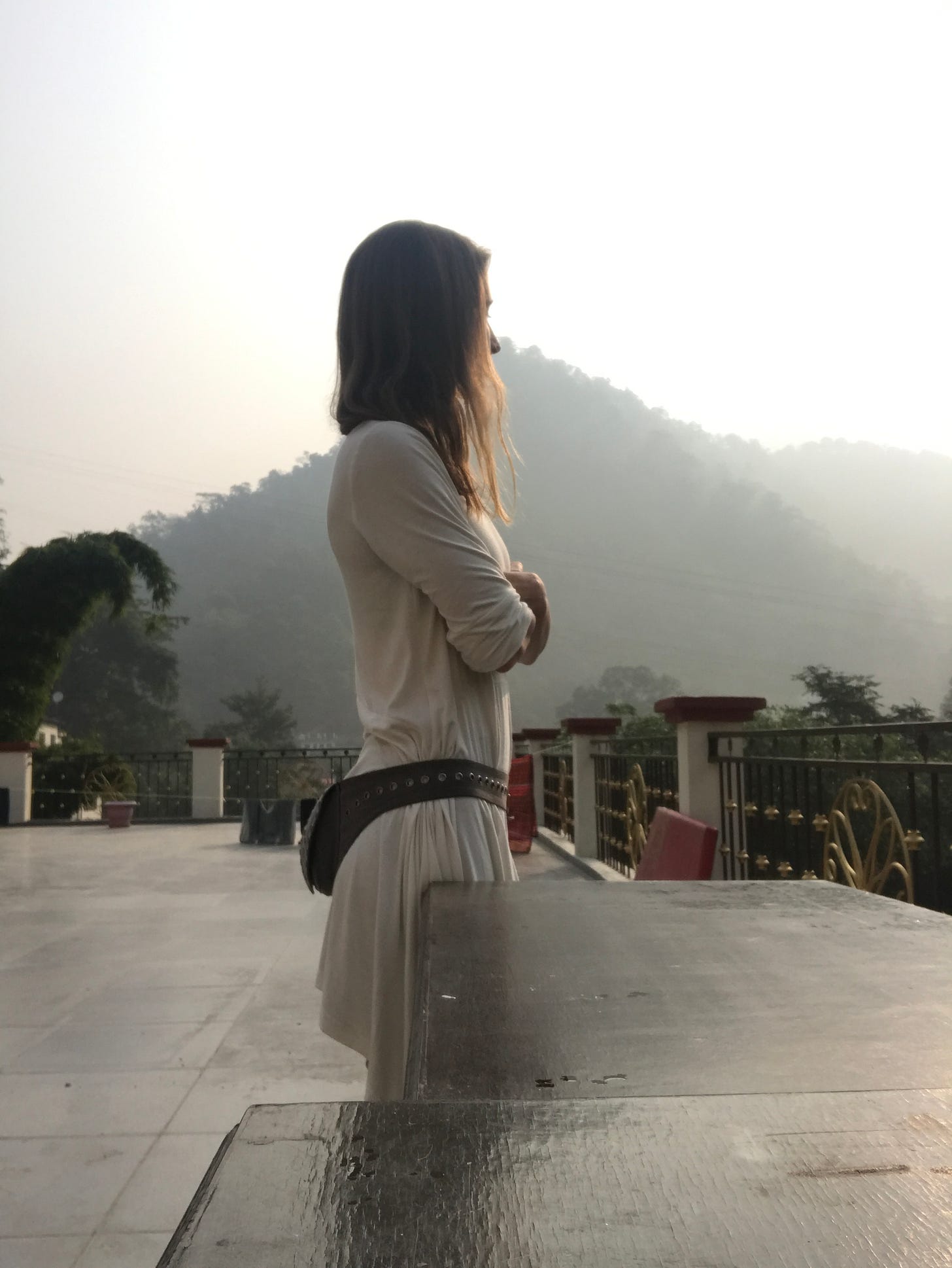 image of the author - Kari Kwinn - outside of Rishikesh, India with a vague fog behind her.