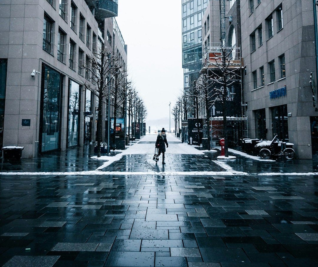 person in black coat walking on street during daytime person in black coat walking on street during daytime