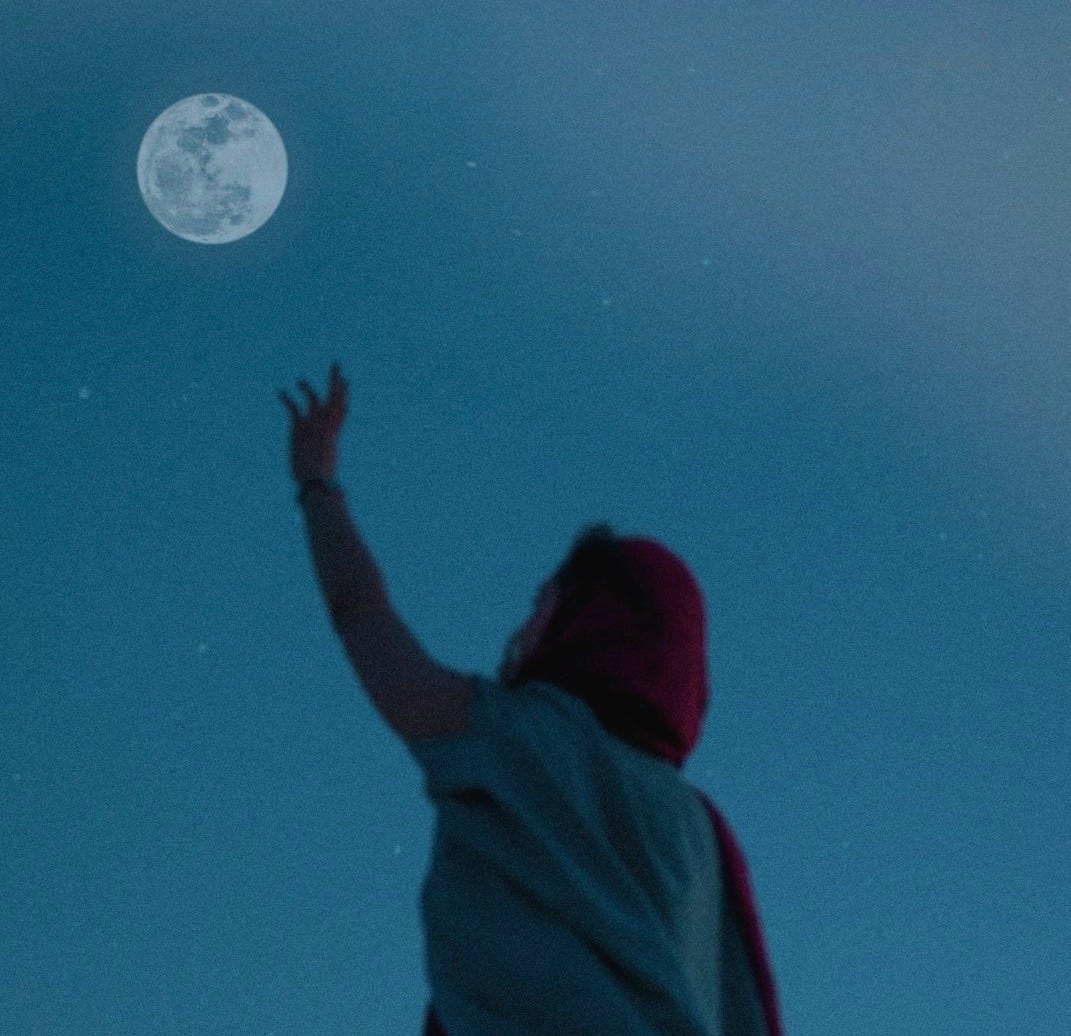 person in red hoodie looking at moon person in red hoodie looking at moon