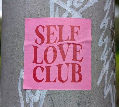 This may contain: a sticker on a pole that says self love club