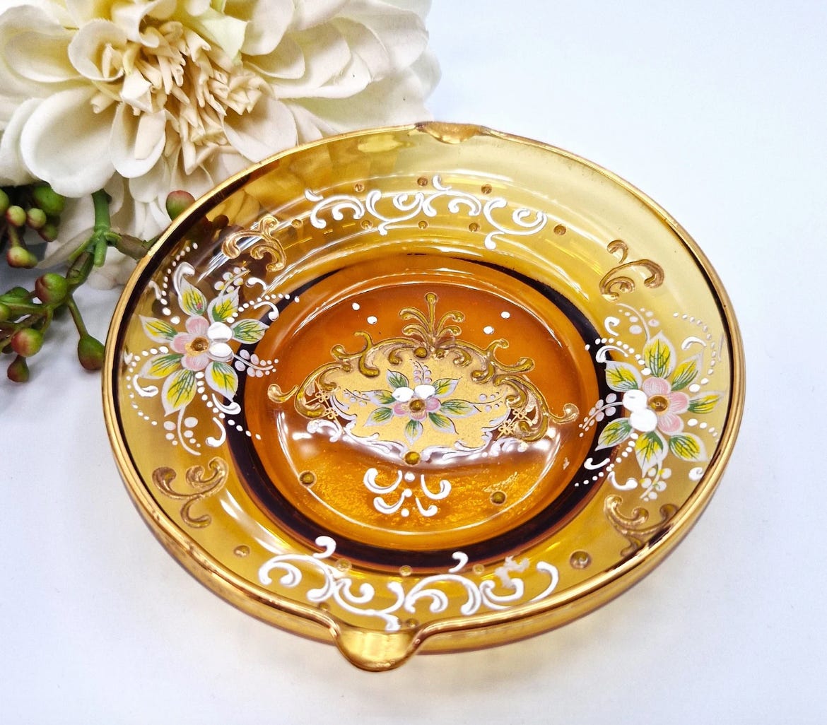 A gorgeous glass dish in translucent orange glass. Stunning hand painted flowers and delicate, ornate embellishments. A gorgeous glass dish in translucent orange glass. Stunning hand painted flowers and delicate, ornate embellishments.