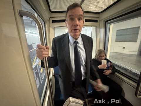 Male politician in dark suit rides underground tram 