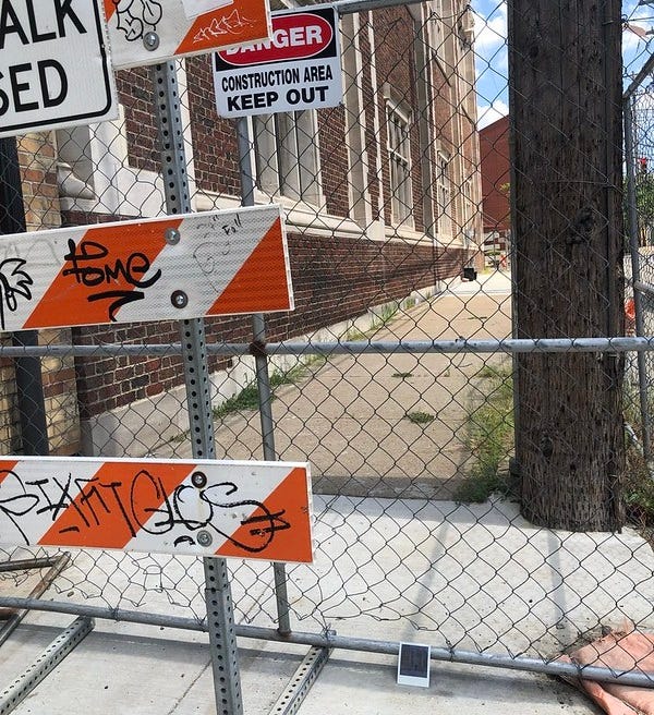 Construction gates along the side of the Oliver Baths building.