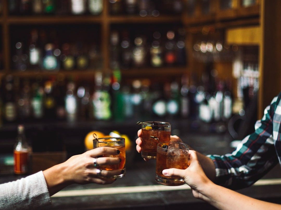 three person holding clear drinking glasses