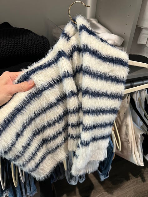 Jeans and sweaters hanging in my closet.