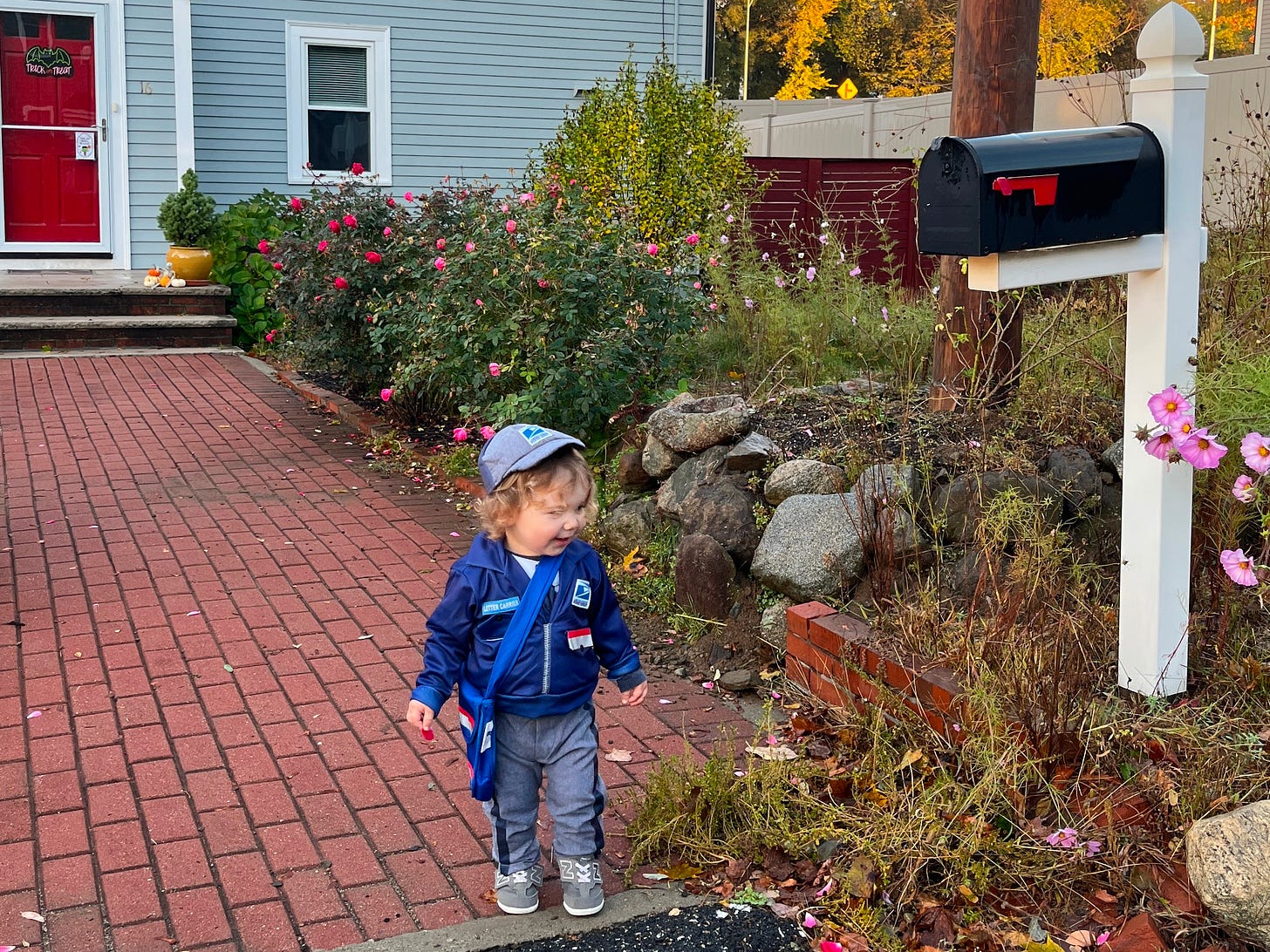 A toddler dressed as a United States Postal Service letter carrier.