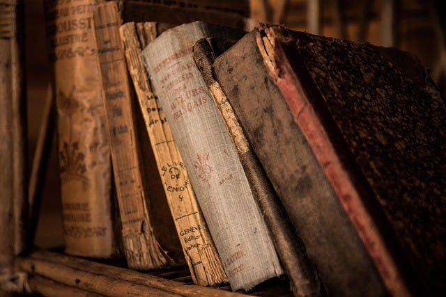 a bookcase with some old dusty books, via Pixabay, in the public domain a bookcase with some old dusty books, via Pixabay, in the public domain