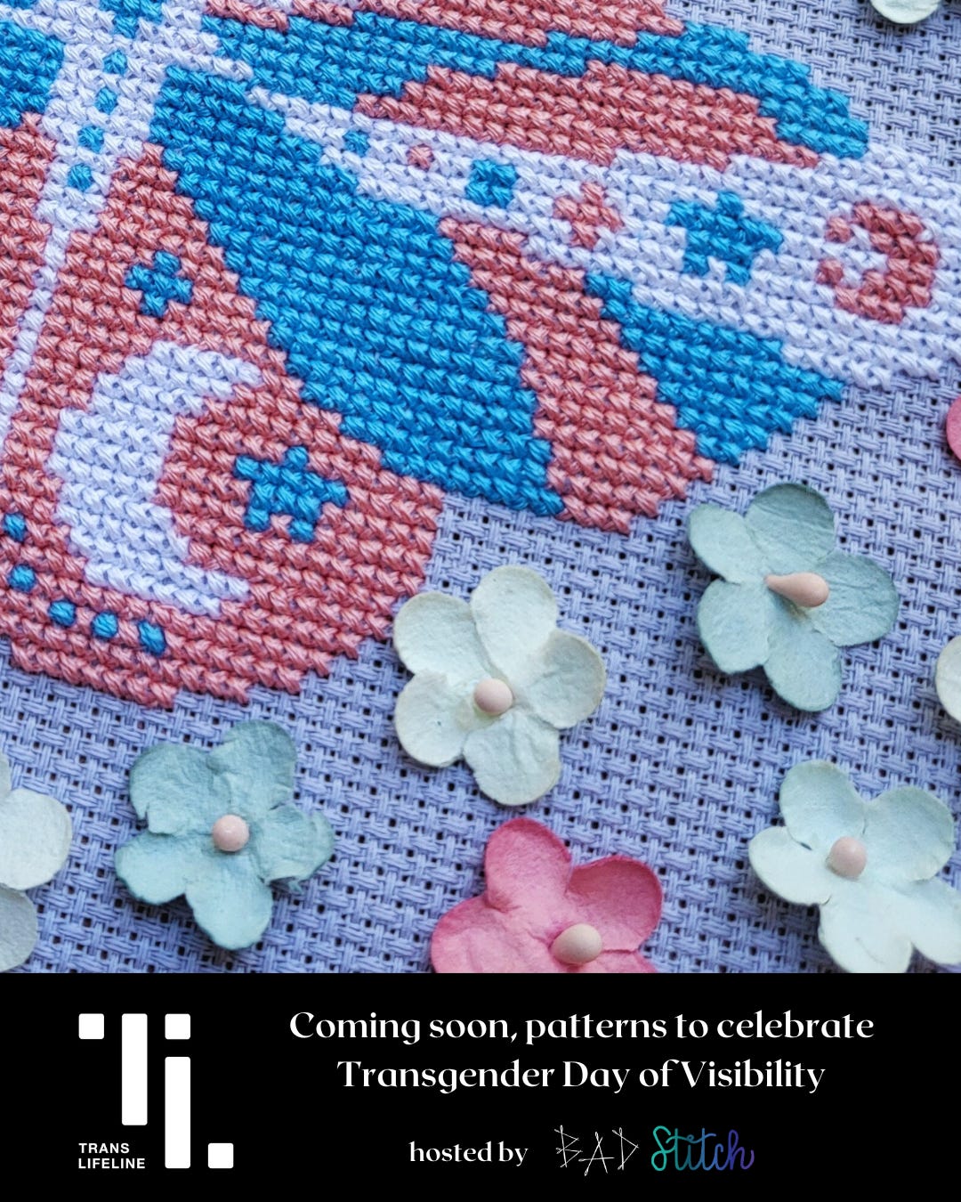 A close up of a cross stitch pattern depicting half of a moth, the wings have small celestial motifs and are stitched in trans flag colors, pink, blue, and white. Trans Lifeline logo.  Coming soon, patterns to celebrate Transgender Day of Visibility. Hosted by BAD Stitch.