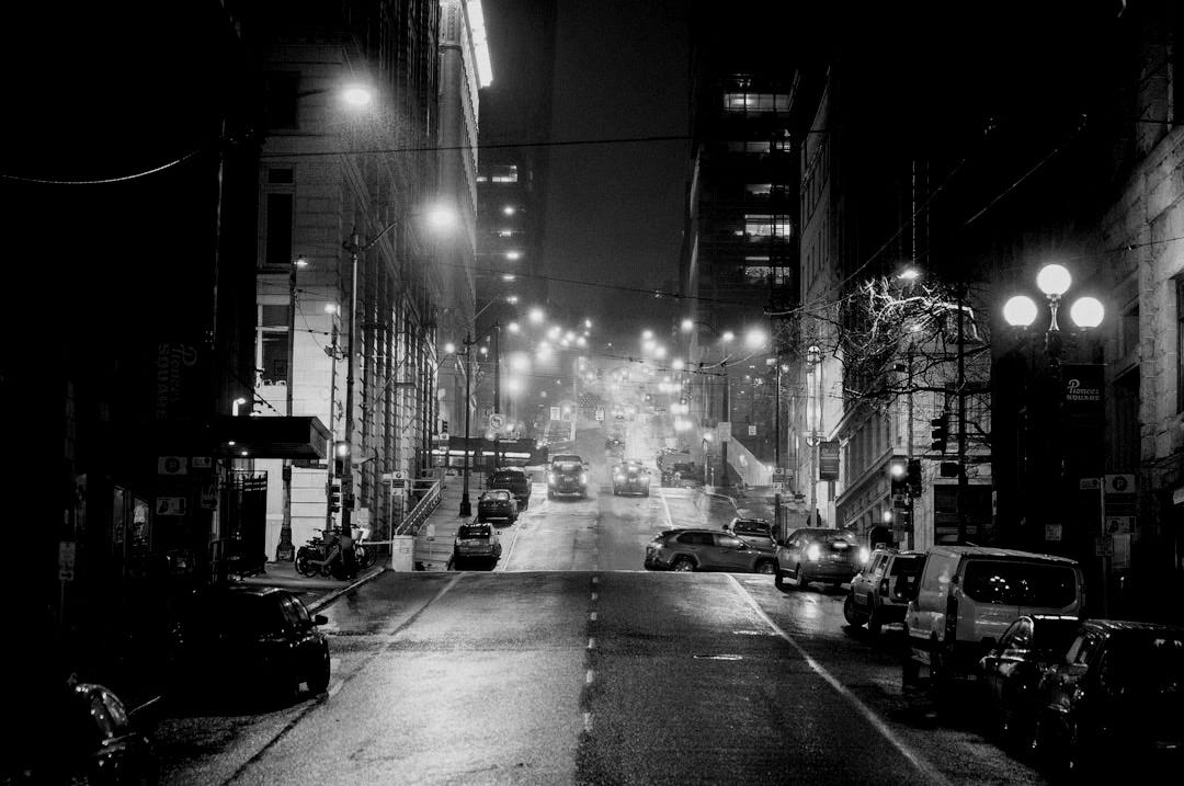 Empty city street reflecting lights at night.