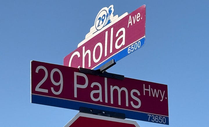 Street signs for Cholla Ave and 29 Palms Highway and completed work on road widening project on Cholla Ave.