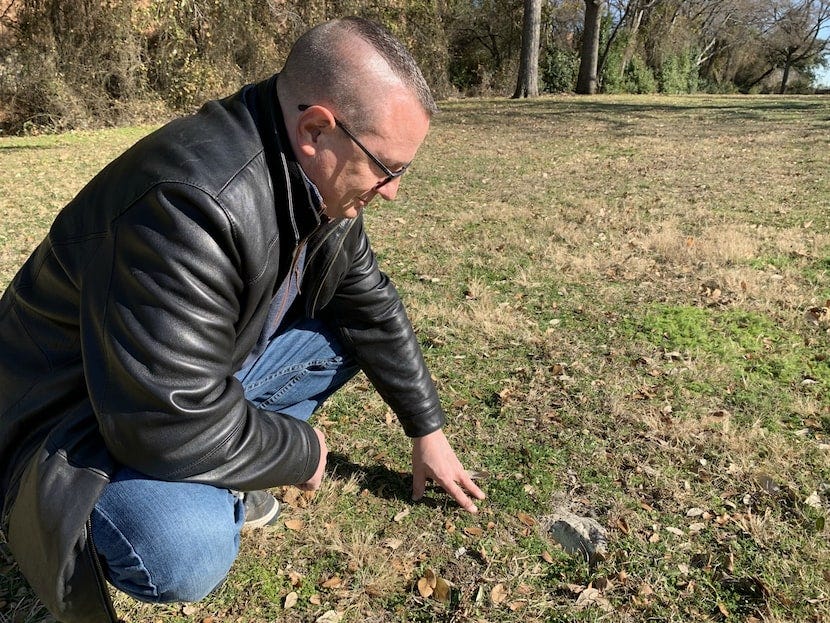 Dan Babb inspects one of the surviving markers at the old Dallas City Cemetery, which has... Dan Babb inspects one of the surviving markers at the old Dallas City Cemetery, which has...
