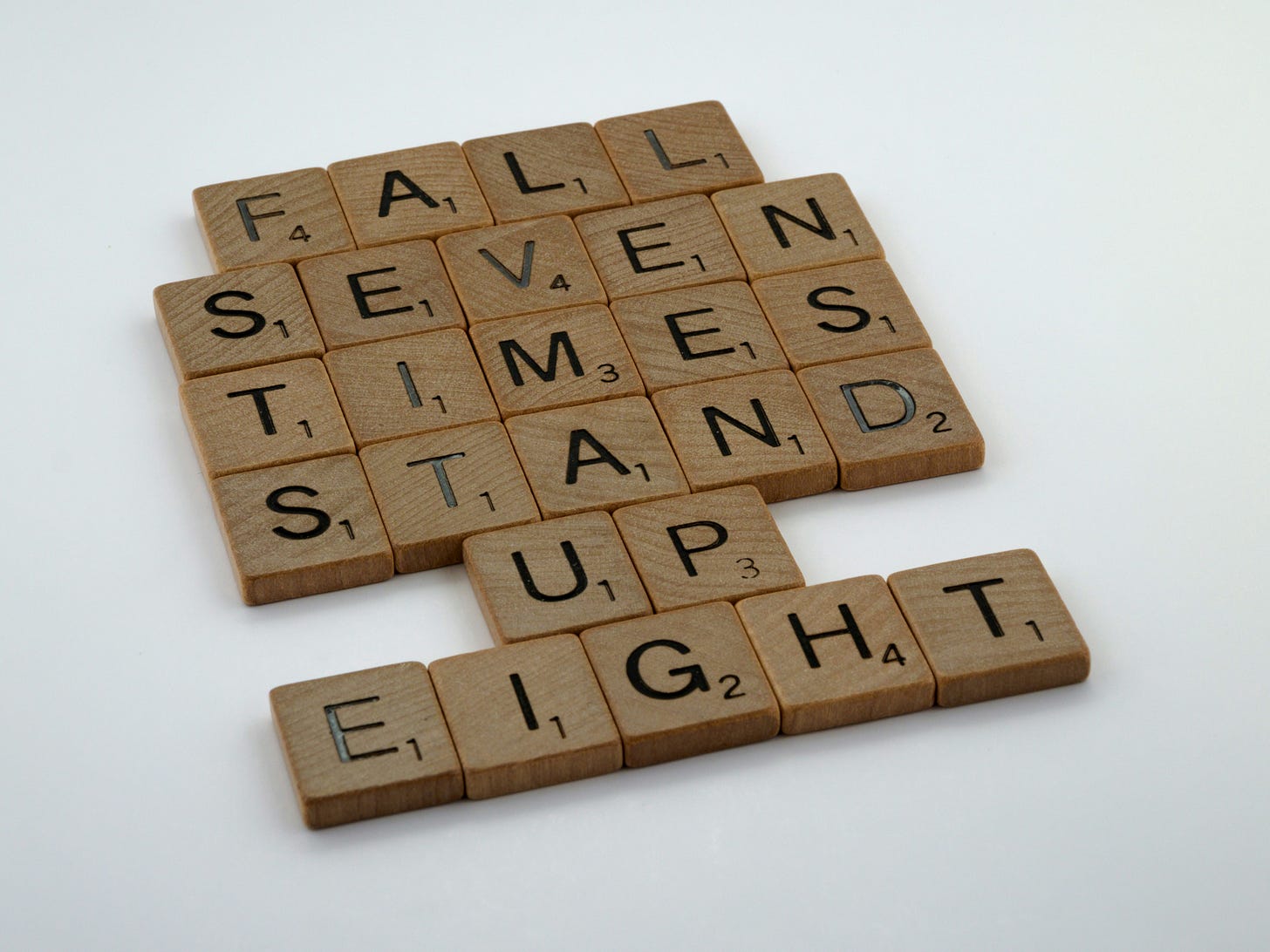Scrabble letters reading: fall seven times, stand up eight Scrabble letters reading: fall seven times, stand up eight