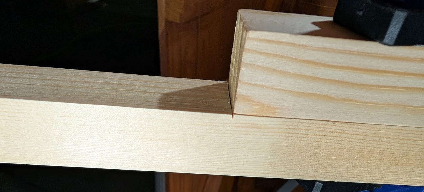 two pieces of lumber, a shorter one on top of a longer one