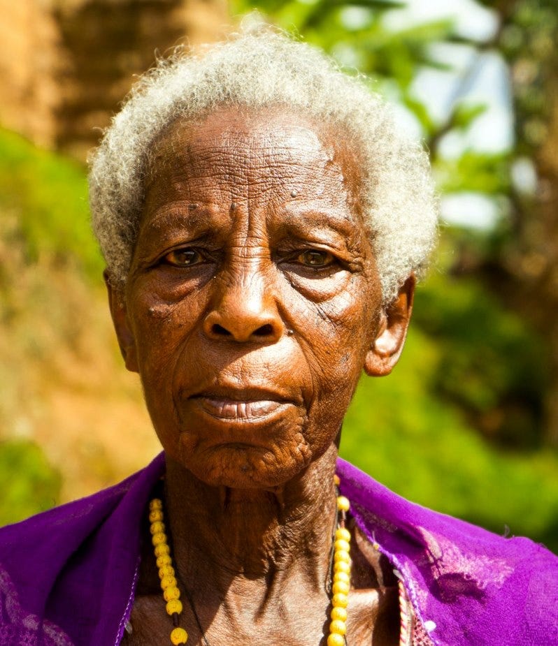 a woman with white hair wearing a purple shirt