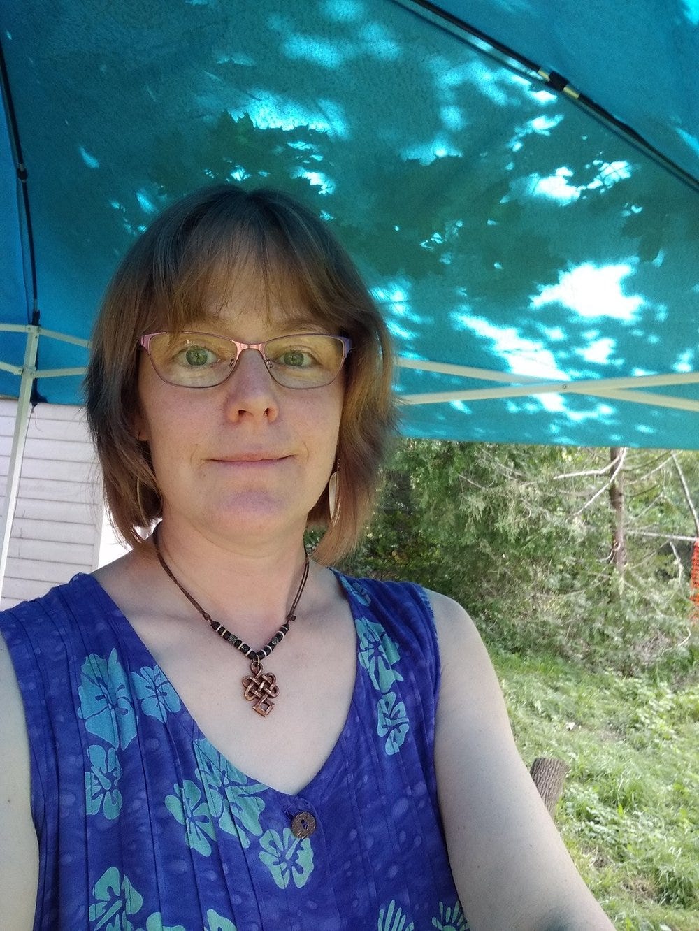 Author Tanah Haney in a blue dress looking forward