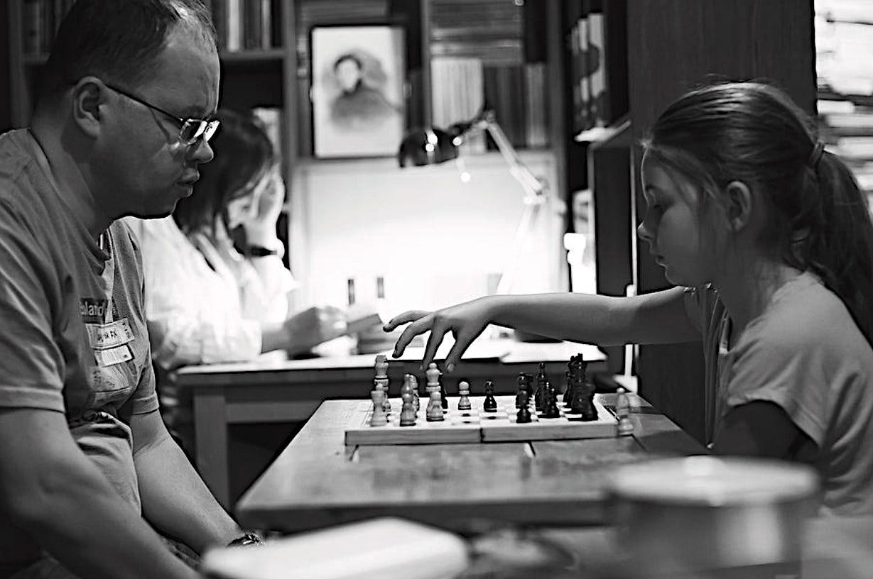 May be an image of 2 people, child, chess and text