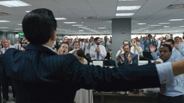This may contain: a group of people standing in an office with their hands up and one person raising his arms