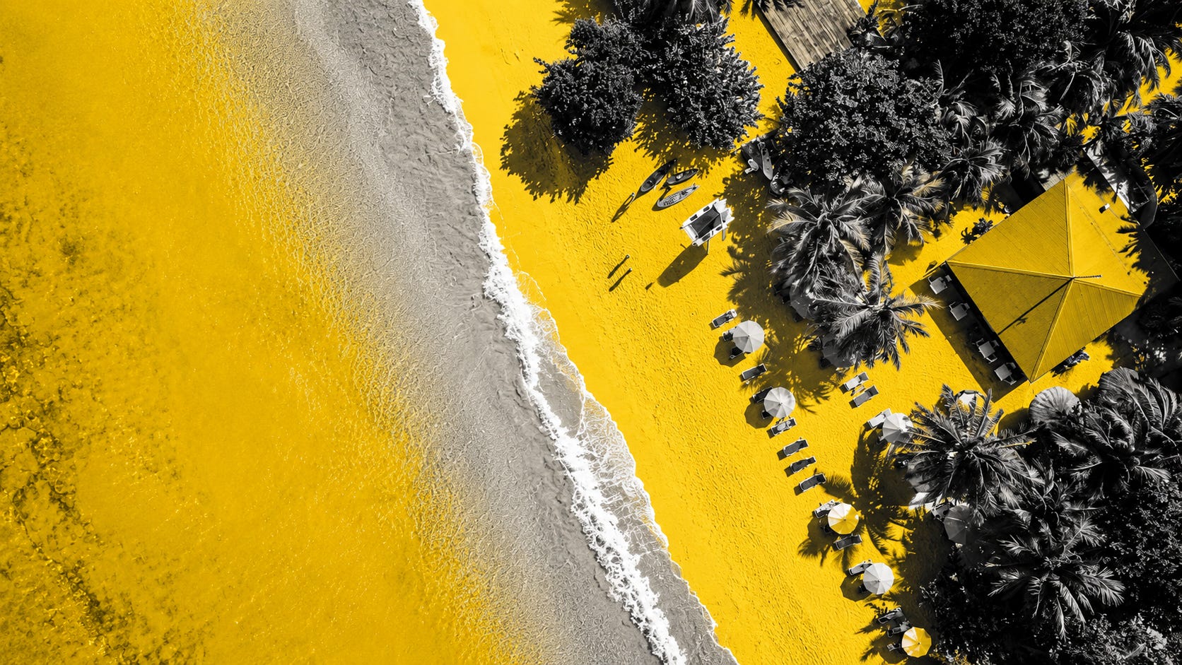 A striking aerial view of a Caribbean shoreline reimagined in bold yellow and grayscale tones, blending luxury, tension, and tropical beauty into a dramatic editorial style. The image captures the growing contrast between paradise and pressure, where some of the world’s most desirable beaches are becoming symbols of ownership, exclusion, and change.