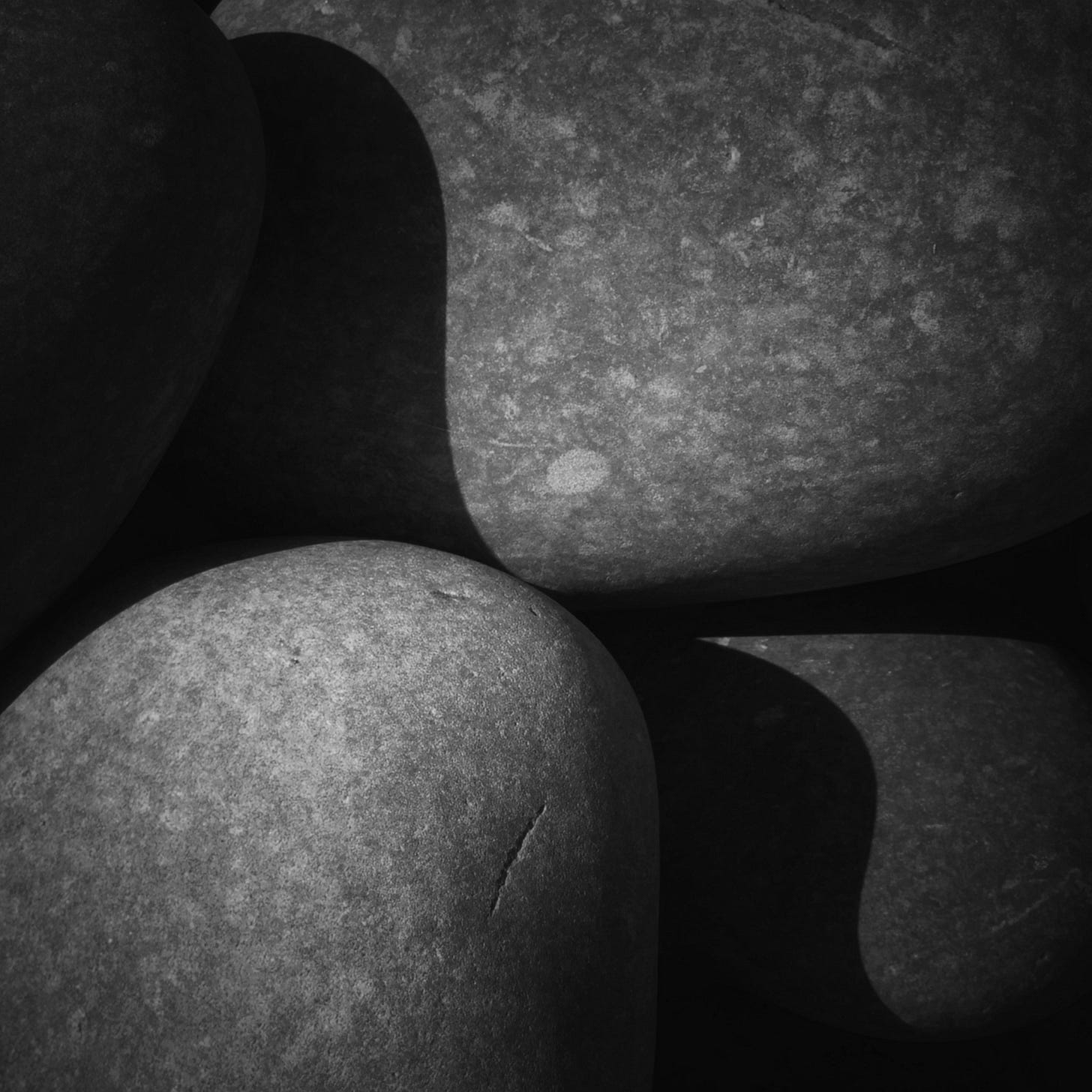 A black and white photograph from Pebble Ridge at Northam Burrows showing the sinuous shadows falling across pebbles making them look wavy