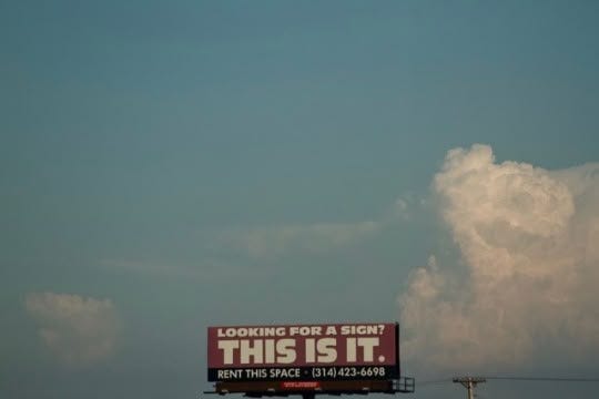 This may contain: an airplane is flying in the sky with a sign that reads looking for a sight this is it
