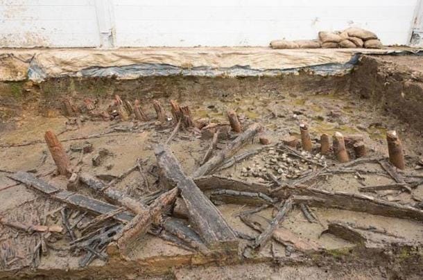 Remains of a house at Must Farm showing the unburnt stumps of posts under the waterline during the fire (top-right) and collapsed joists