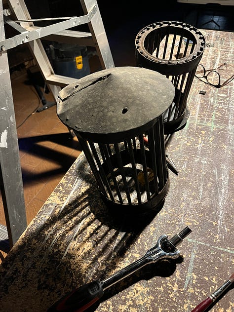 A wooden frame for storing and painitng wooden panels and tools and a series of coffee can lanterns in the process of being restored.