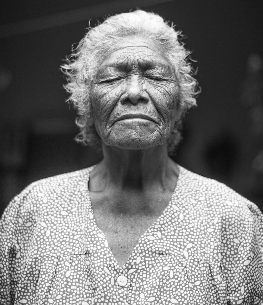 grayscale photo of closed-eyes woman