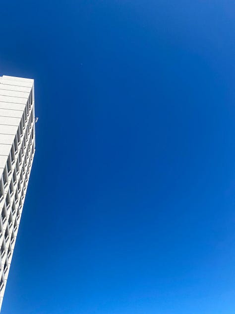 A white skyscraper against a cloudless blue
