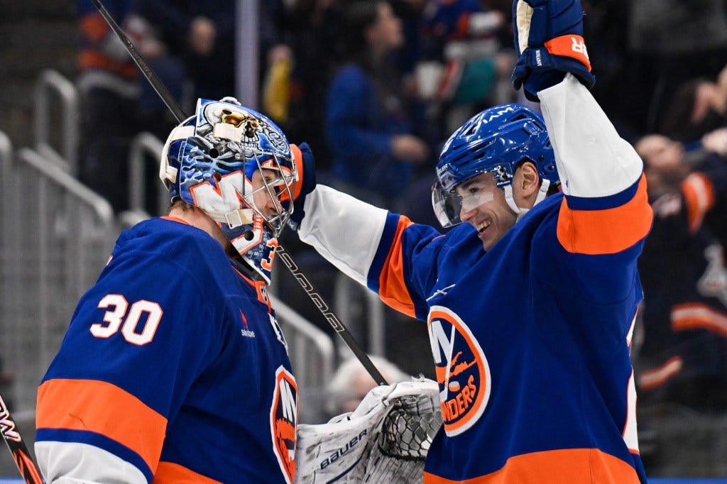 New York Islanders defenseman Alexander Romanov (28) celebrates the 2-1 victory against the Vegas Golden Knights with New York Islanders goaltender Ilya Sorokin (30) after the game at UBS Arena.