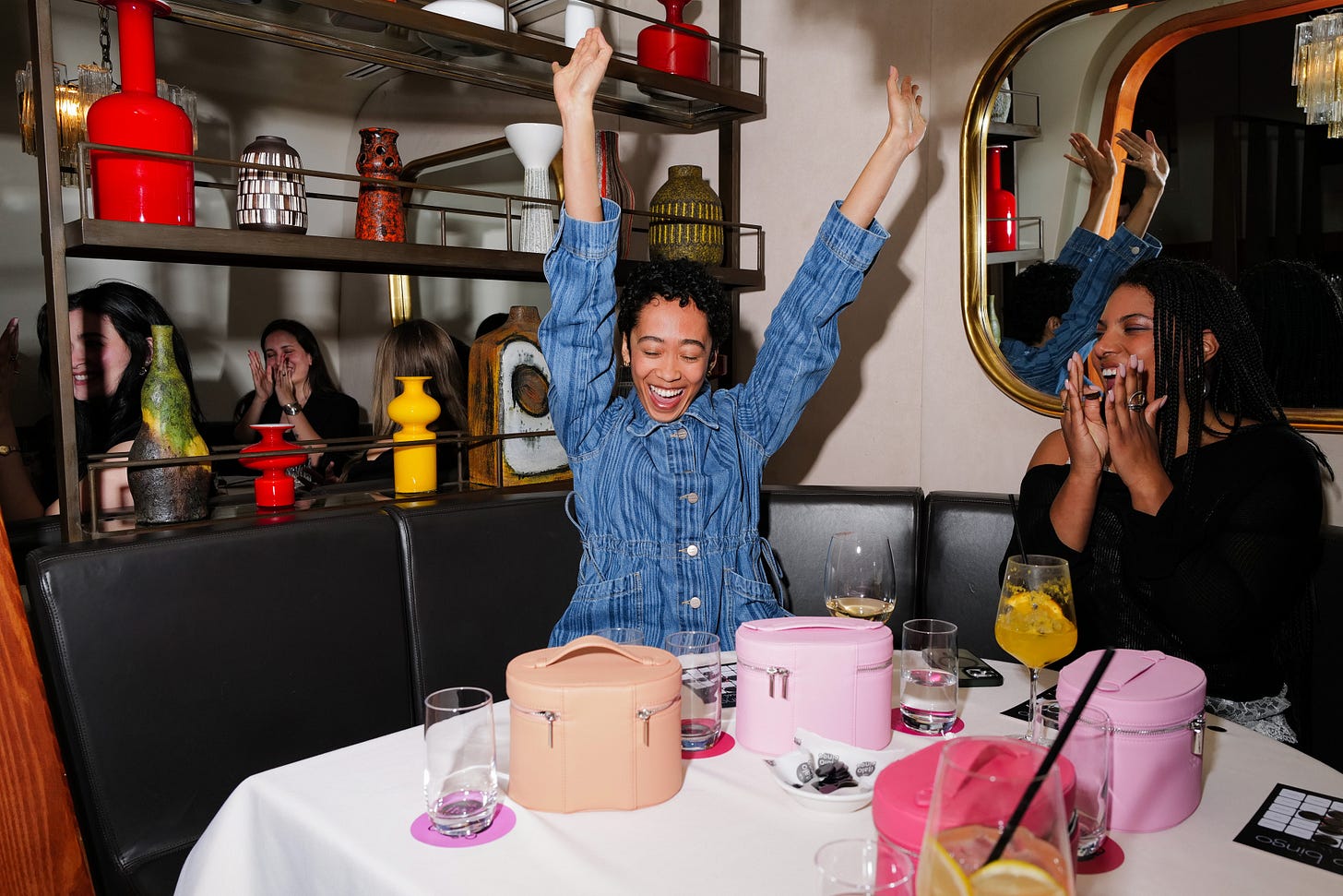 Two women playing bingo, one has her arms up in the air. 