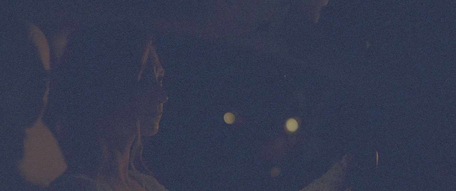 A barely visible color image of a bride sitting in a car. The negative was fogged and the resulting image is washed out and contains almost no image information