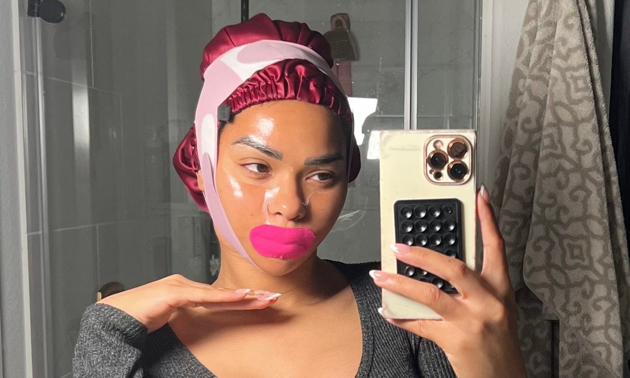 Veronica Ellis taking a selfie, while wearing a face mask, chin strap, mouth tape and a silk bonnet.