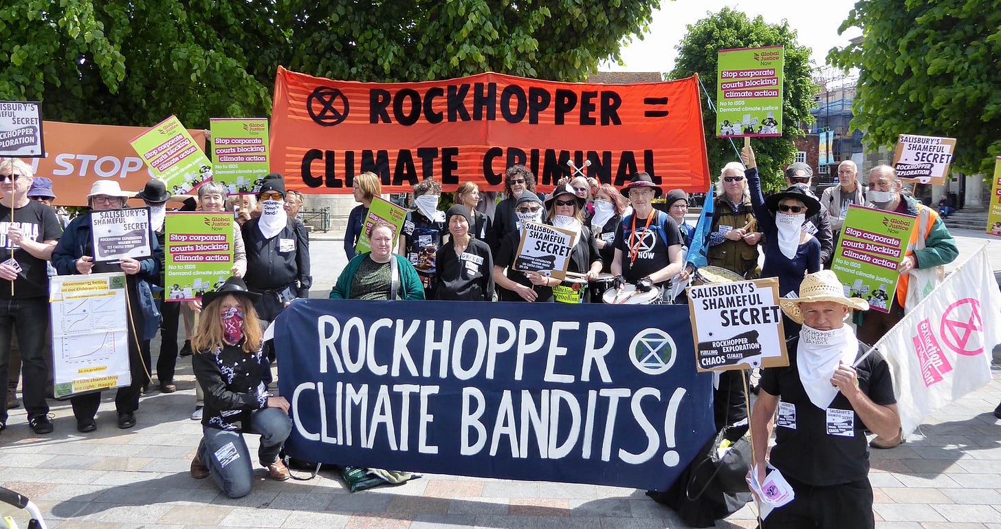 Protestors outside in the UK holding banners that say 'Rockhopper: climate bandits!' Protestors outside in the UK holding banners that say 'Rockhopper: climate bandits!'