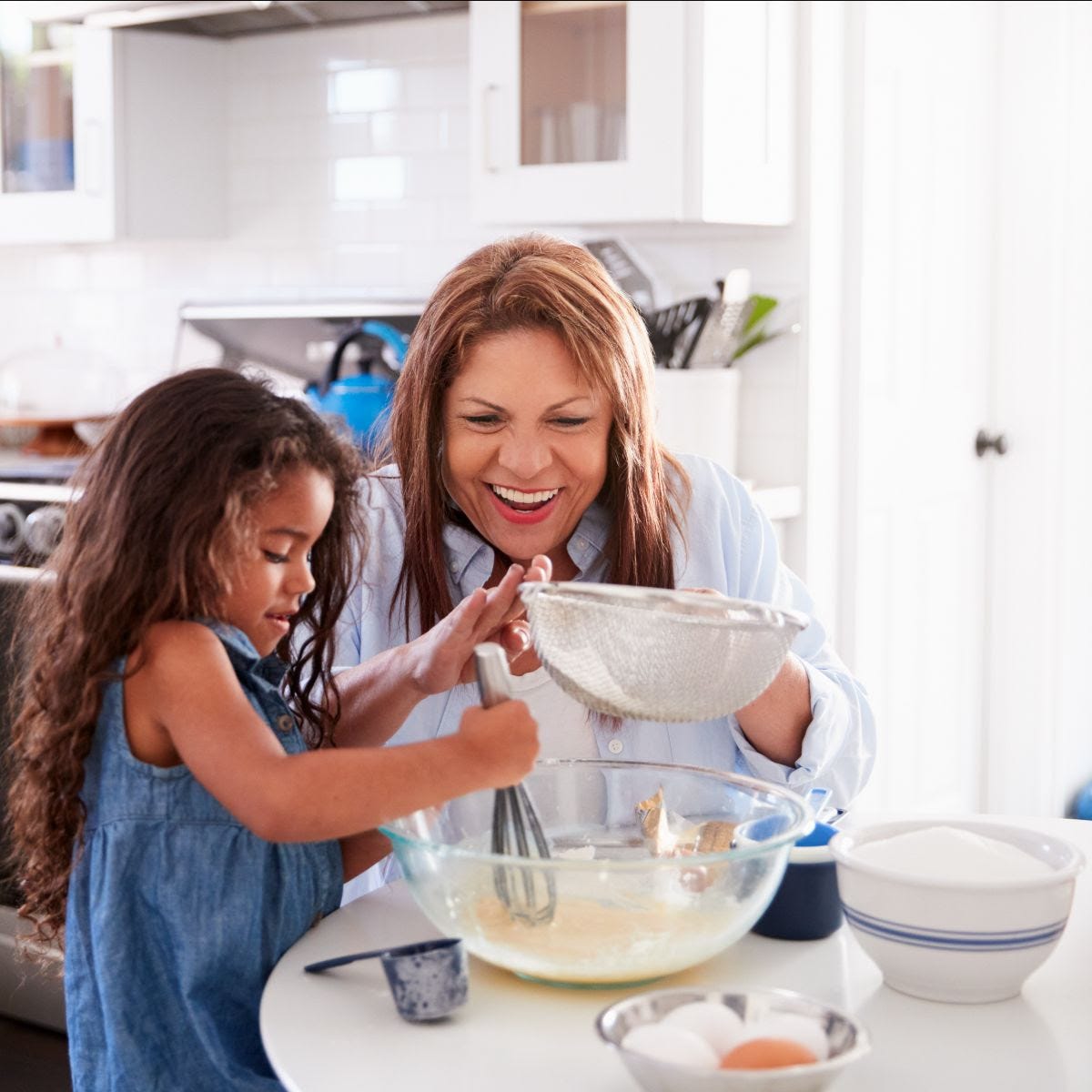 A photo of a grandmother and grandchild cooking together.