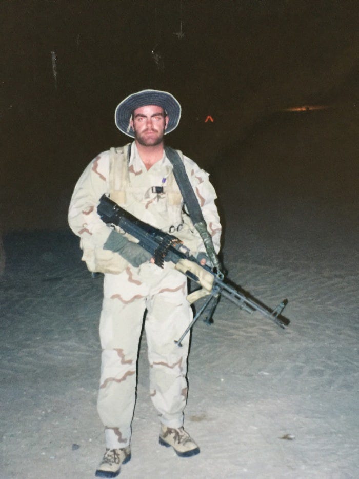 Brandon Webb in desert camouflage with a machine gun at the Naval Special Warfare Desert Warfare training center.