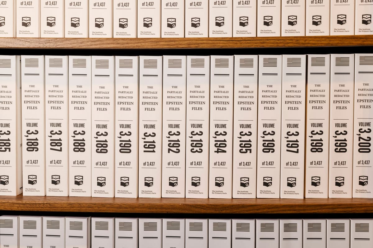 Stacked and opened volumes of the printed Epstein files