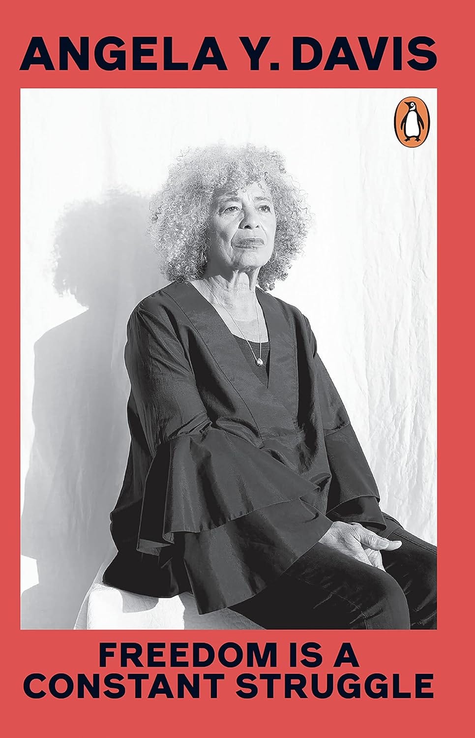 Penguin Books edition book cover for Angela Y. Davis's Freedom is a Constant Struggle. Red back ground with a black and white portrain of Angela Davis sitting down wearing a blouse with bell sleeves.