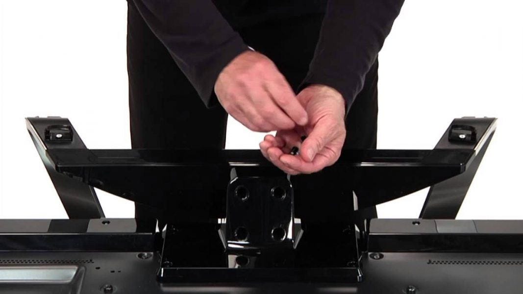 Attach 4k TV to bracket for motorized monitor. Man screwing in bracket. Attach 4k TV to bracket for motorized monitor. Man screwing in bracket.